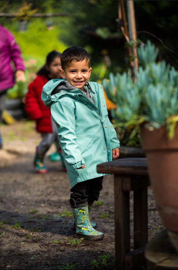 Young boy in garden with rain boots