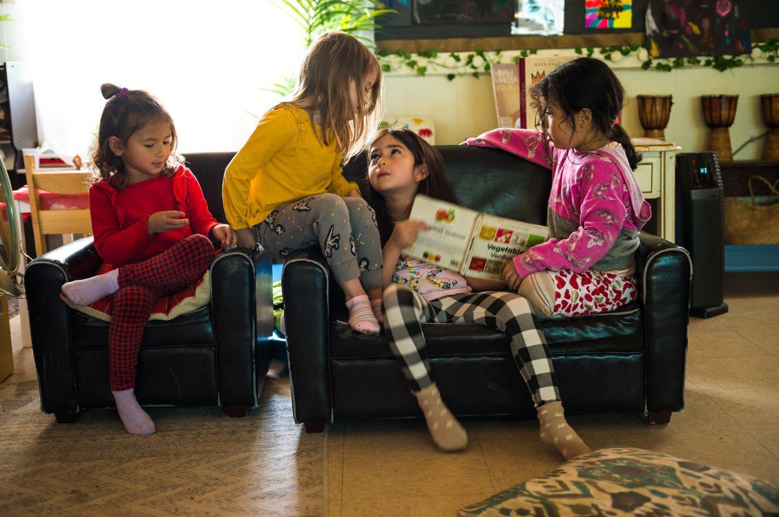 Children reading together on a couch